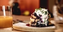 photograph of stacked pancakes and blueberry compote.
