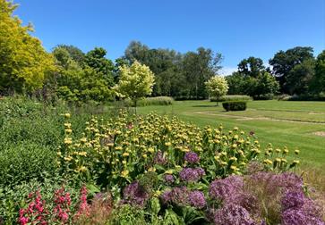 wide flower border with lawn at michelham priory.