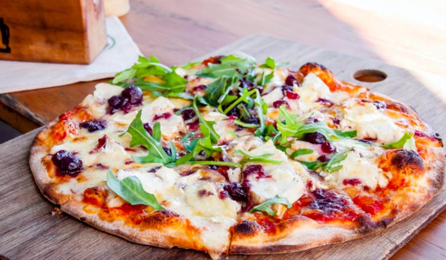 a photograph of a pizza on a wooden chopping board