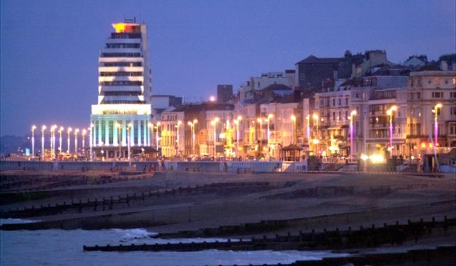 a photograph of st leonards seafront with large art deco building and promenade street lamps in twilight.