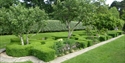 Formal gardens with box hedging and trees.