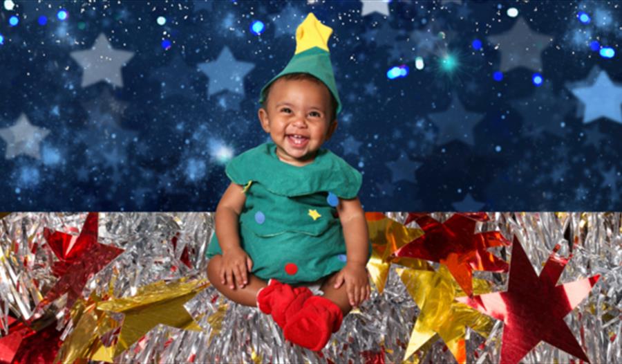 A small child dressed as a Christmas tree. A small child dressed as a Christmas tree.