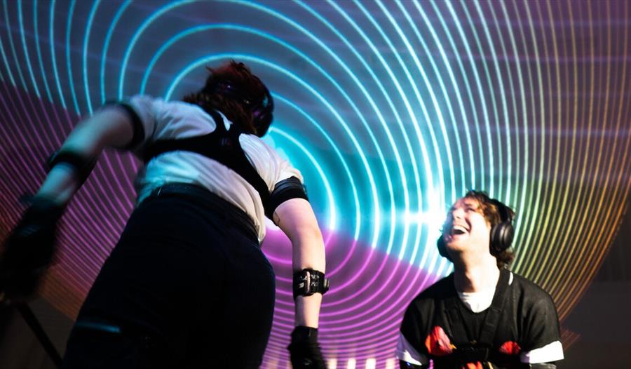 two young people in room with bright spiralling coloured lights. two young people in room with bright spiralling coloured lights.