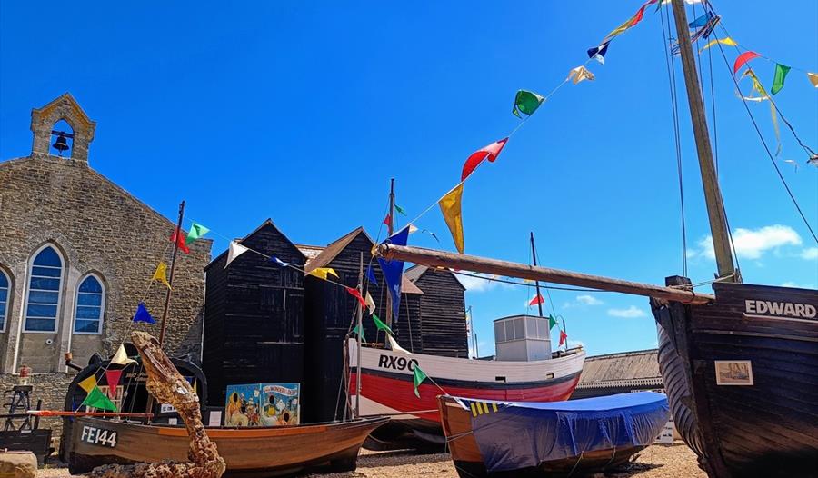 coloured bunting, black net huts and fishing boats