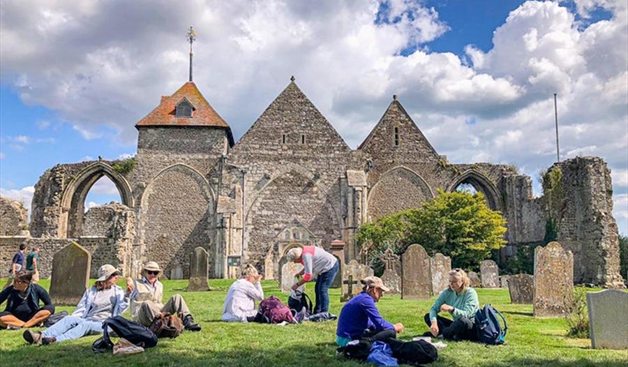 Church ruins with people sitting in the graveyard