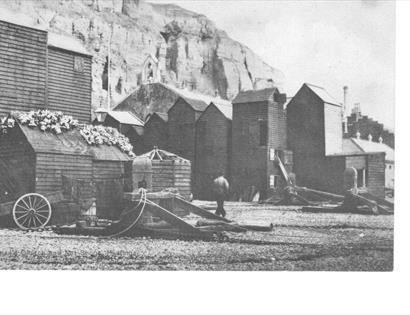 black and white photograph of Hastings Rock-a-nore area with fishing huts on the beach.