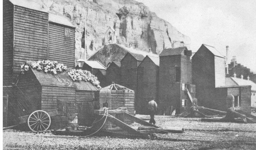 black and white photograph of Hastings Rock-a-nore area with fishing huts on the beach.