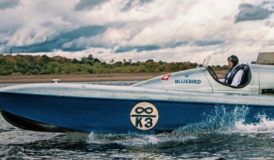 blue and silver power boat with driver, says 'bluebird' and 'k3'.
