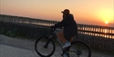 sunset view of a bike cycling along a seafront.