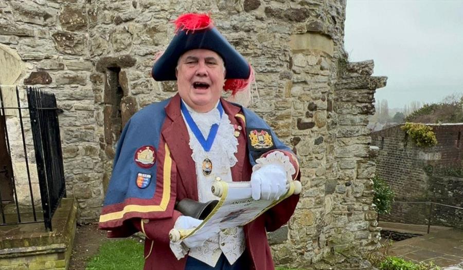 photograph of town crier in traditional costume reading from a scroll