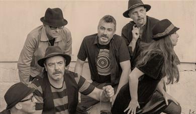Black and white publicity photograph of the Mad Dog Mcrea band members striking different poses