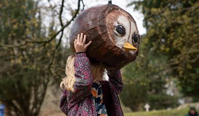 Girl trying on a giant bird head