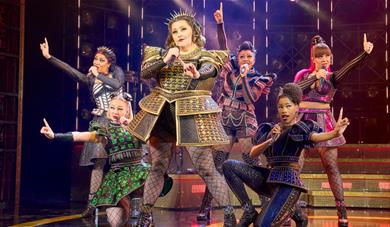 Six female performers singing on stage