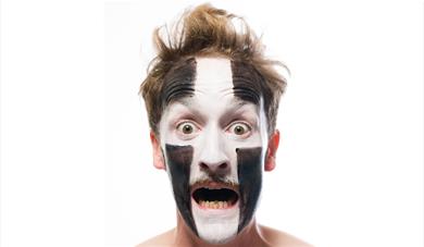 Man with face paint and a shocked expression