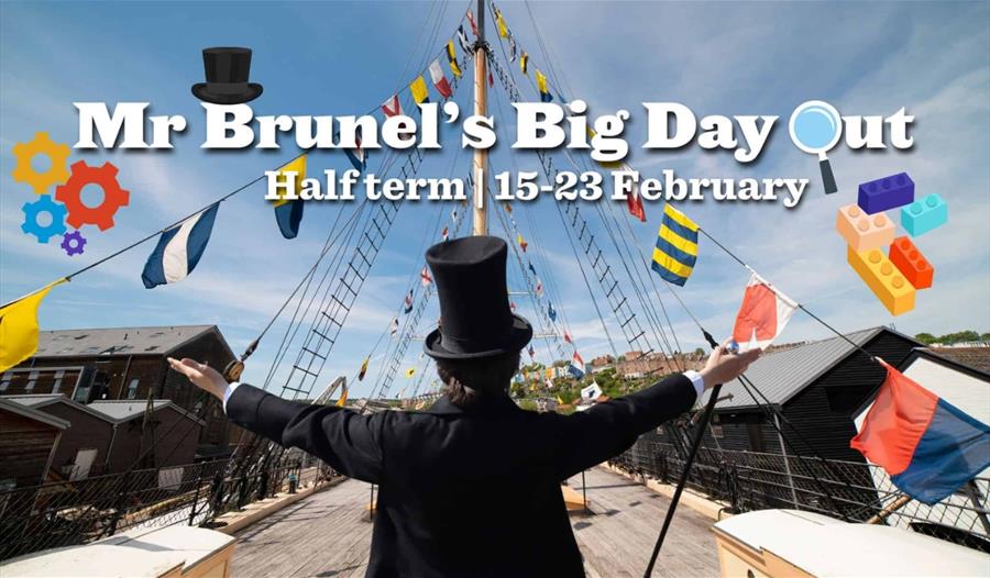 Mr Brunel dressed in Victorian clothing including stovepipe hat stands with his back to the viewer with his arms in the air. He stands on the deck of
