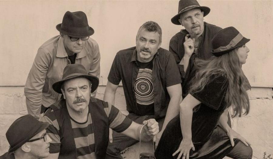 Black and white publicity photograph of the Mad Dog Mcrea band members striking different poses