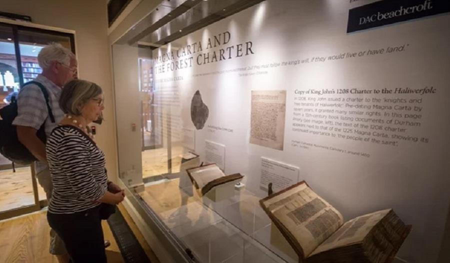 Two visitors to the Cathedral Museum looking at the Magna Carta display from 2017