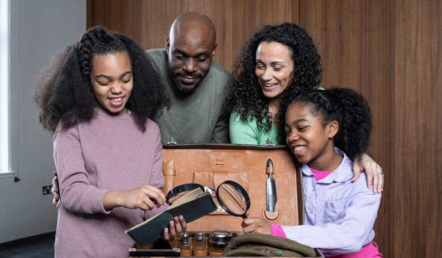 Image of a family all looking at museum artifacts
