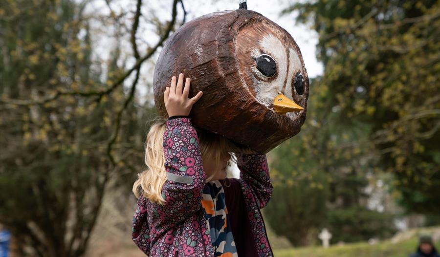 Girl trying on a giant bird head