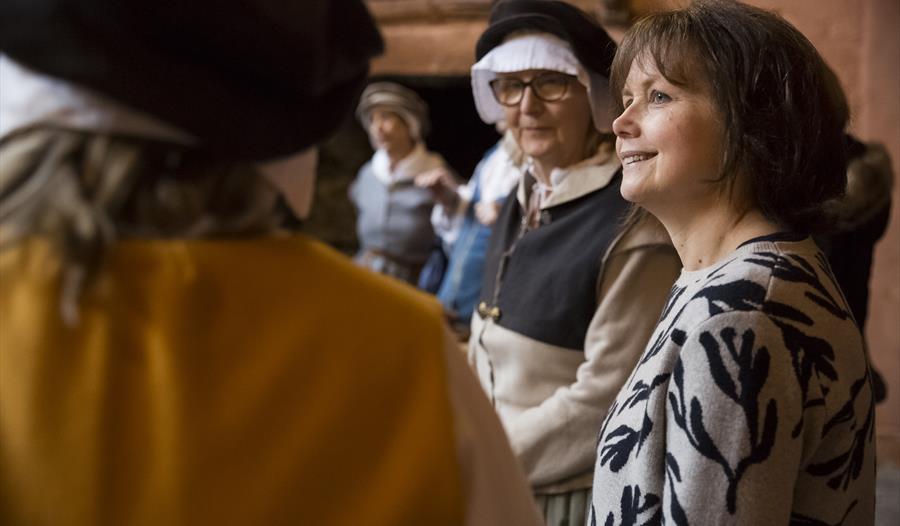 Volunteers talking with visitors in the Buckland Abbey kitchen