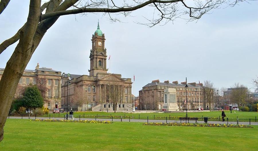 Historic buildings in Hamilton Square surround a grass square.