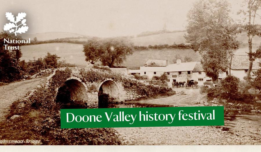 A historic image in black and white of a stone bridge over a ford