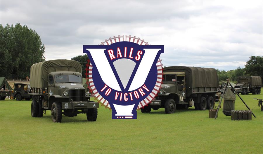 Several classic military vehicles parked in a field, with Rails To Victory branding over the top
