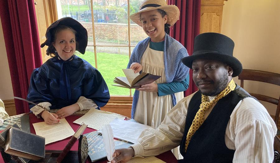 Victorian characters at a round table.