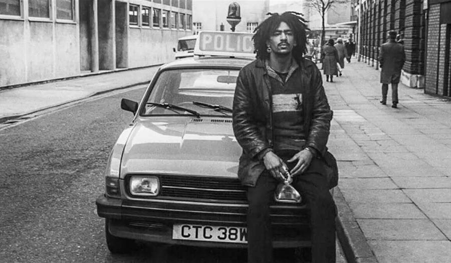 Man sitting on car bonnet in black and white photo