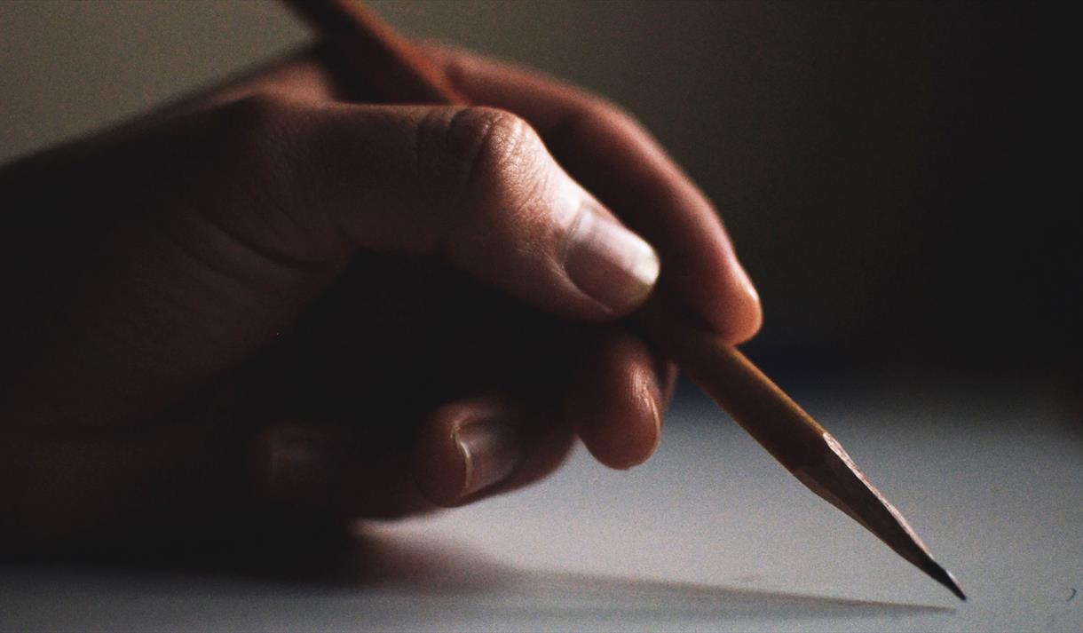 A hand holding a pencil