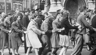 A photo from VE day in Leicester with people dancing round the clock tower