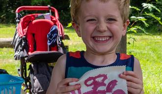 child holding up painting outdoors