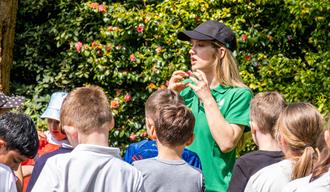 children gathered listening to guided talk outside