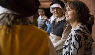 Volunteers talking with visitors in the Buckland Abbey kitchen
