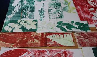 A number of prints made with leaves in green and red inks