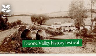 A historic image in black and white of a stone bridge over a ford