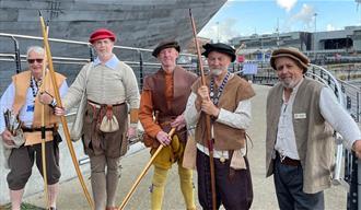 Archers gathered outside The Mary Rose in Tudor wear.