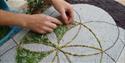 Adding leaves to the well dressing