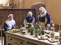 Volunteers in Tudor costume cooking in the Buckland Abbey Kitchen