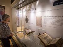 Two visitors to the Cathedral Museum looking at the Magna Carta display from 2017