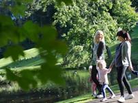 Two women and three children walking around the lake at Hardwick Park