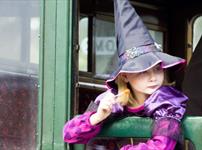 Girl dressed up as a witch looking out of the carriage window at the Wizard Week event, Isle of Wight Steam Railway, what's on