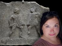 A photograph of Alexandra Sills in front of an image of Amazon and Achillea - the female fighters of Halicarnassus