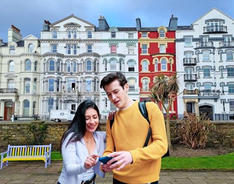 Couple playing Go Quest Adventures on the Douglas promenade.