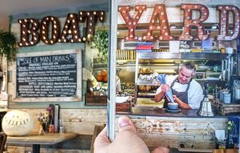 Picture shows a chef preparing dessert in the open hatch of the kitchen