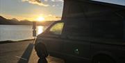 Campervan set up on the Isle of Skye with morning sunrise in the background