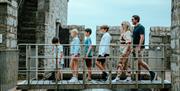 A family walking across the drawbridge into Castle Rushen