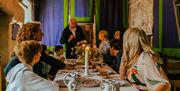 A family listening to Lester, a Castle Rushen guide, in the medieval dinning room of the castle.