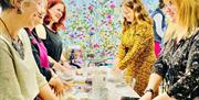 A group of women smile and chat whilst baking