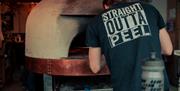Pizza being put in pizza oven